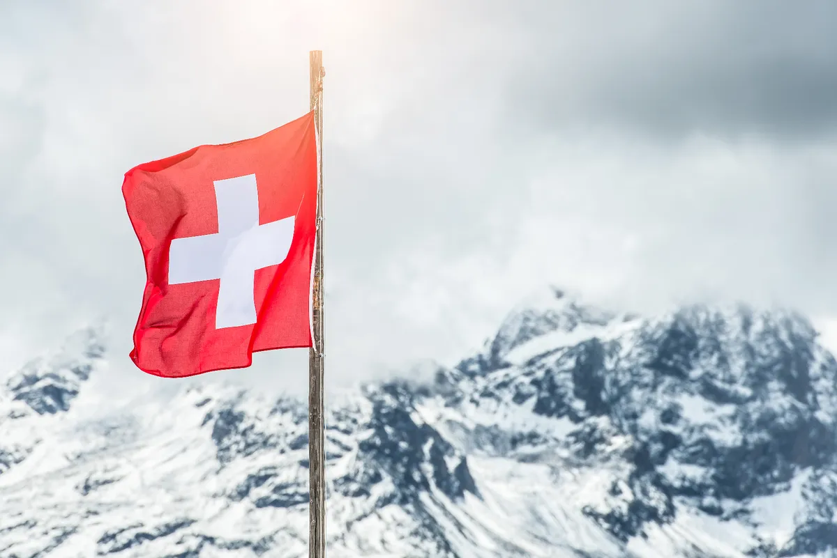 Schweizer Flagge vor Alpen